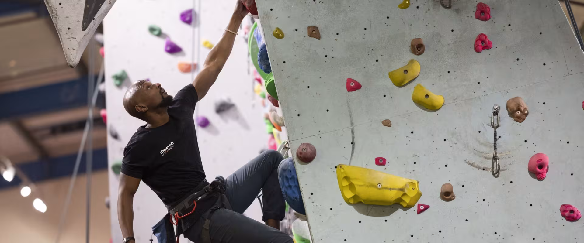 Climber hanging from one arm on an overhang 